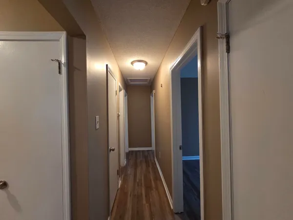 a view of a hallway with wooden floor