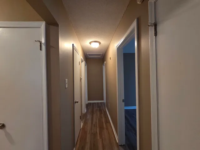 a view of a hallway with wooden floor