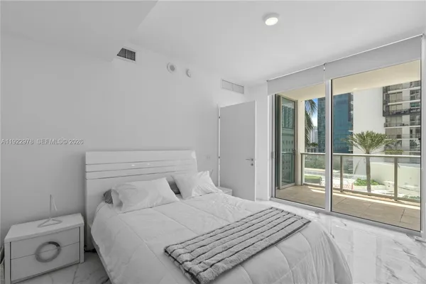 a bedroom with a bed and a large window