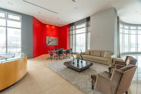 a living room with furniture and floor to ceiling windows