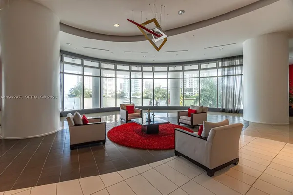 a living room with furniture and floor to ceiling windows