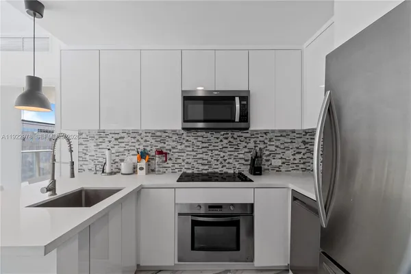 a kitchen with stainless steel appliances a stove a sink a microwave and cabinets