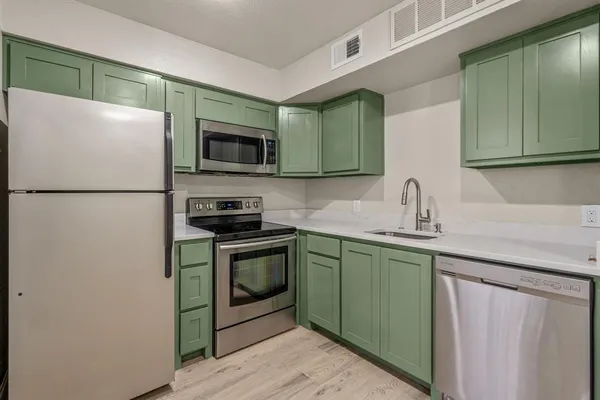 a kitchen with stainless steel appliances granite countertop a sink and cabinets