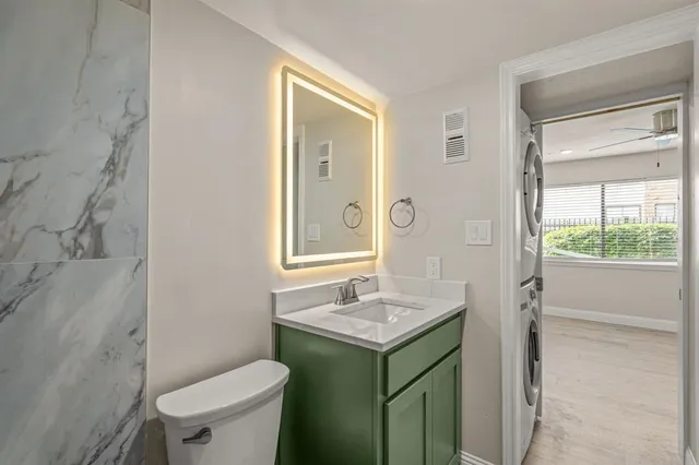 a bathroom with a sink vanity mirror and toilet