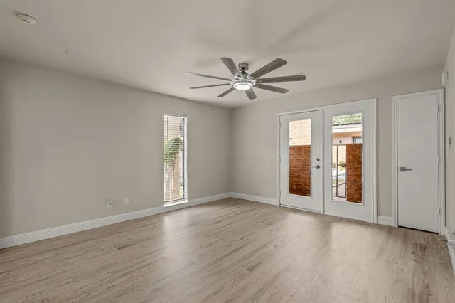 a view of an empty room with a window and a kitchen