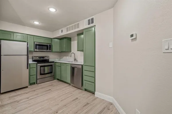a kitchen with stainless steel appliances granite countertop a refrigerator and a stove top oven