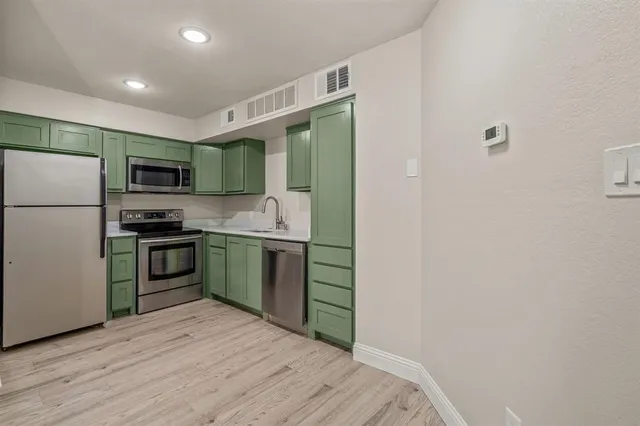 a kitchen with stainless steel appliances granite countertop a refrigerator and a stove top oven