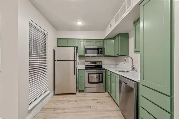 a kitchen with stainless steel appliances granite countertop a refrigerator and a sink