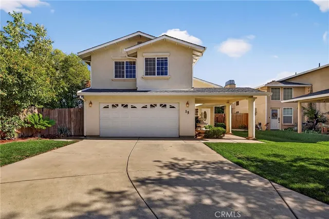 a front view of a house with a yard and mountain view in back