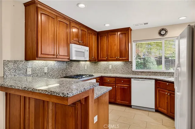 a kitchen with stainless steel appliances granite countertop wooden cabinets a sink and dishwasher