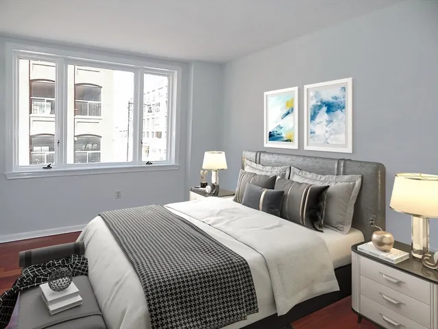 a bedroom with a bed and a lamp on dresser