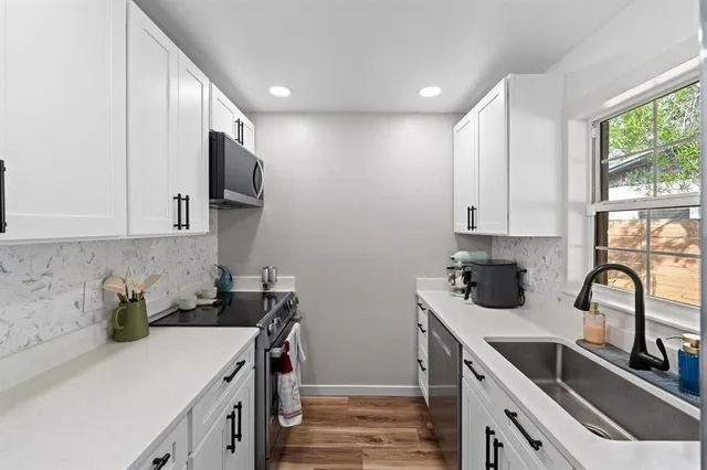 a kitchen with stainless steel appliances granite countertop a sink stove and cabinets
