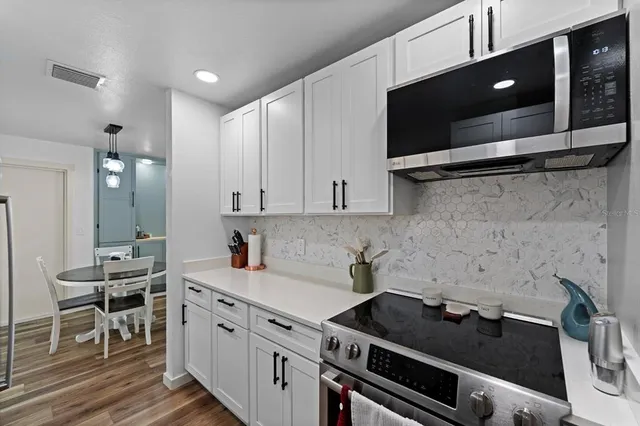 a kitchen with stainless steel appliances a sink stove and cabinets