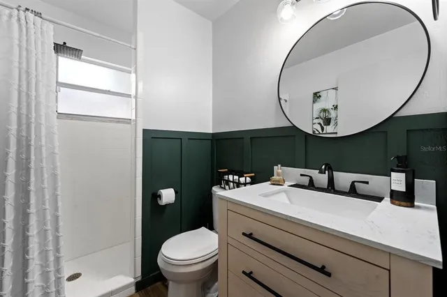 a bathroom with a toilet a sink and a mirror