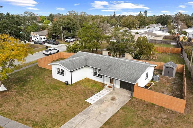 an aerial view of residential houses with outdoor space and trees