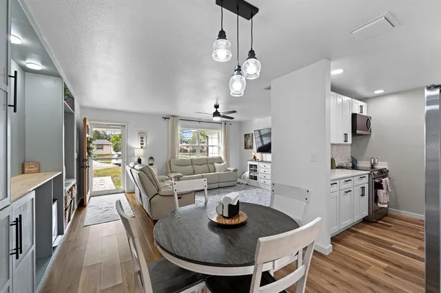 a view of a dining room with furniture a chandelier and wooden floor