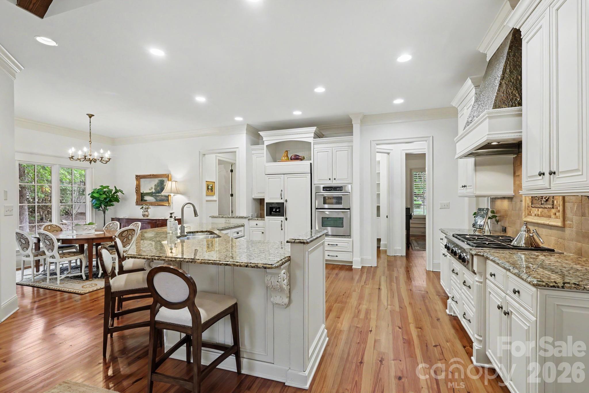 508 Hideaway Ridge Court Matthews, NC 28105 - Photo 22 of 47 a view of a kitchen with kitchen island stainless steel appliances a table and chairs in it