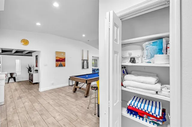 a living room with stainless steel appliances kitchen island granite countertop a sink and a counter top space