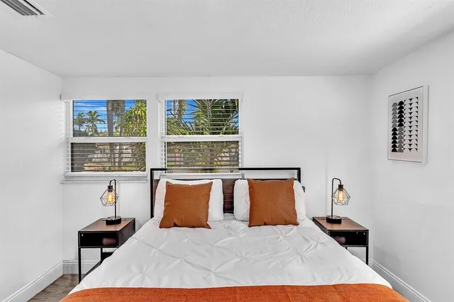 a bedroom with a bed and a painting on the wall