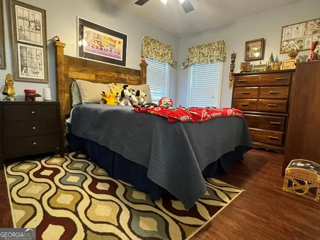 a bedroom with a bed and dresser with racks on the wall