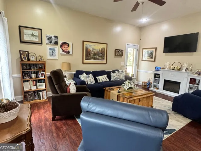 a living room with furniture a flat screen tv and a fireplace