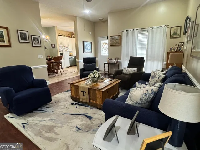 a living room with furniture ceiling fan and a wooden floor