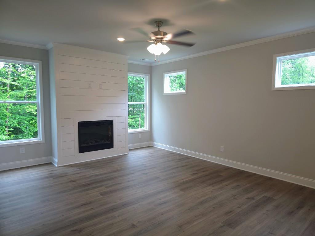 4240 Cavalier Way Duluth, GA 30097 - Photo 5 of 46 an empty room with windows a fireplace and a ceiling fan