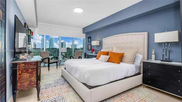 a bedroom with a bed and painting on the wall