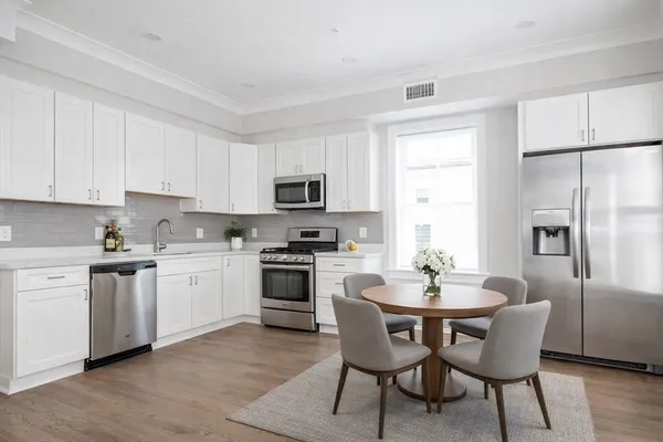 a kitchen with stainless steel appliances granite countertop a kitchen island hardwood floor sink and stove