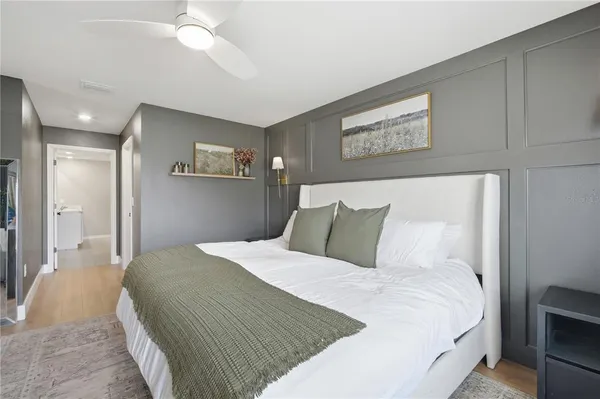 a bedroom with a large bed and a chandelier