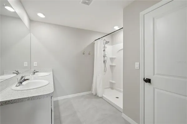 a bathroom with a granite countertop sink a mirror and a shower
