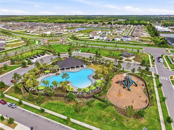 an aerial view of a residential houses with outdoor space and a lake view