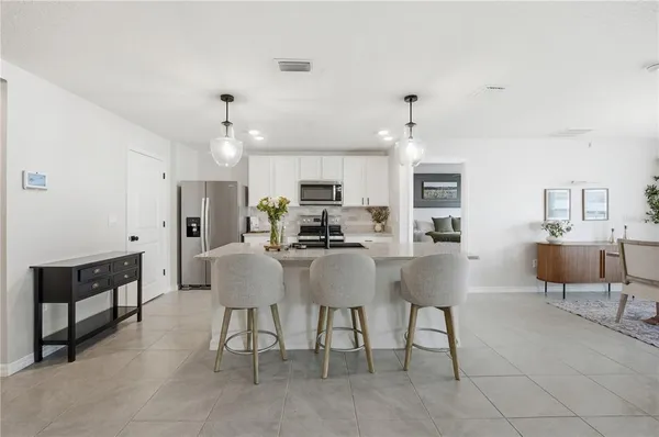a view of kitchen with dining area refrigerator and window