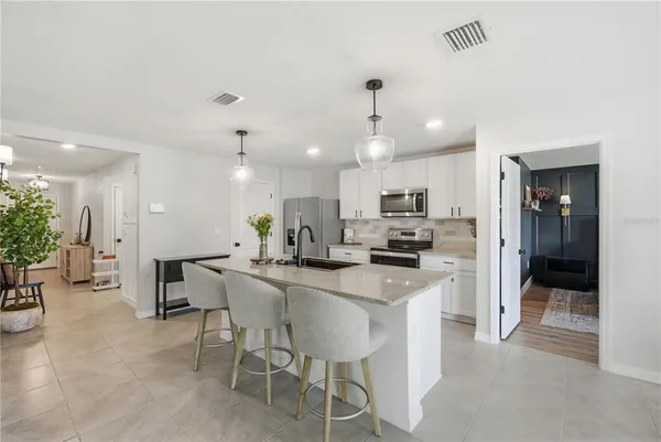 a kitchen with a sink and chairs