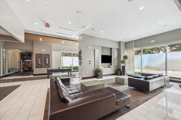 a large living room with stainless steel appliances kitchen island granite countertop a large window and couch