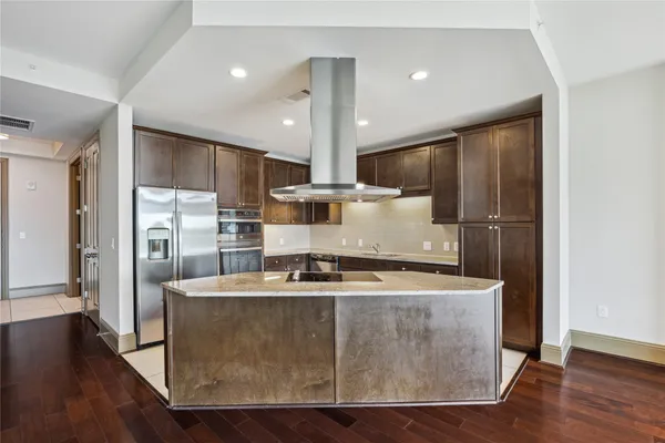 a kitchen with kitchen island stainless steel appliances a sink and a refrigerator