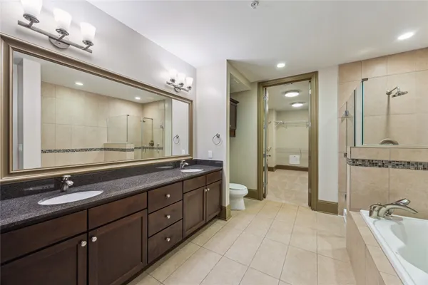 a bathroom with a double vanity sink a large mirror and a shower