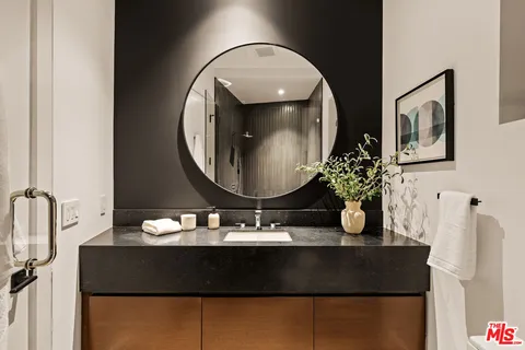 a living room with a table chairs and a mirror