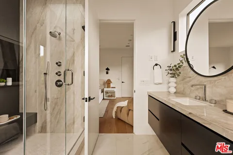 a en suite bathroom with a granite countertop tub sink and mirror