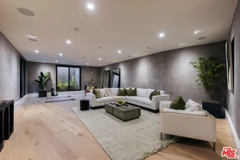 a living room with furniture potted plant and a large window