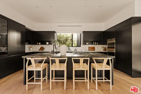 a kitchen with a dining table chairs and refrigerator