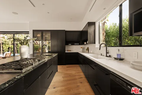 a kitchen with a sink stove top oven and large window