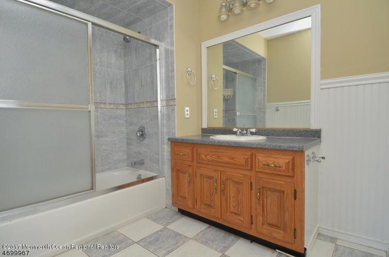 5 D Brookside Heights, Unit 102 Wanaque, NJ 07465 - Photo 13 of 15 a bathroom with a granite countertop sink mirror and bathtub
