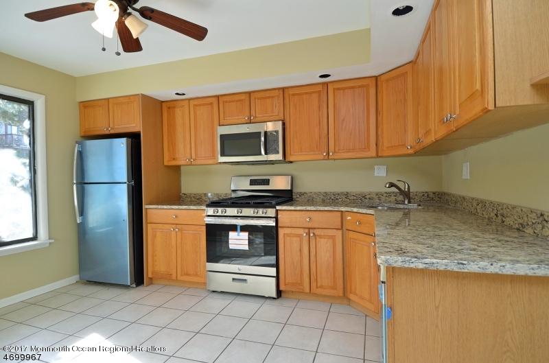 5 D Brookside Heights, Unit 102 Wanaque, NJ 07465 - Photo 4 of 15 a kitchen with stainless steel appliances granite countertop a refrigerator a stove top oven a sink and dishwasher