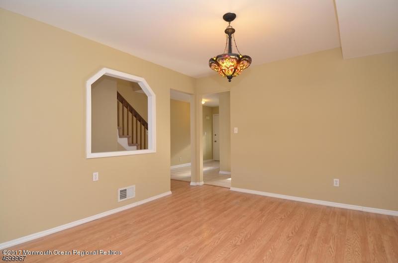 5 D Brookside Heights, Unit 102 Wanaque, NJ 07465 - Photo 6 of 15 an empty room with a chandelier fan and wooden floor