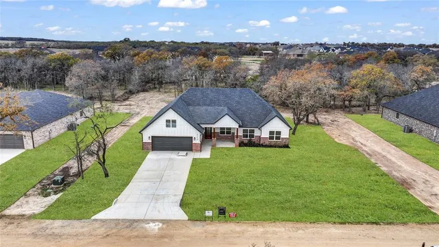an aerial view of a house next to a yard and lake view