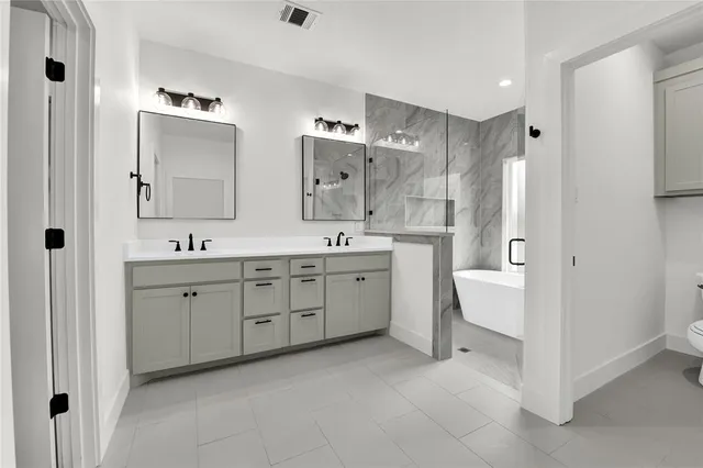 a spacious bathroom with a double vanity sink a mirror and a bathtub