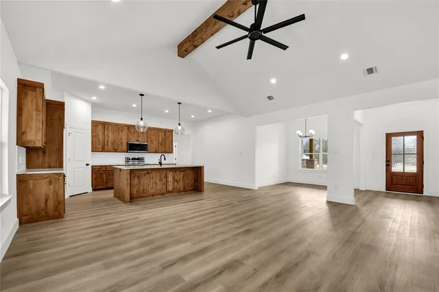 a view of kitchen with refrigerator microwave and stove with wooden floor