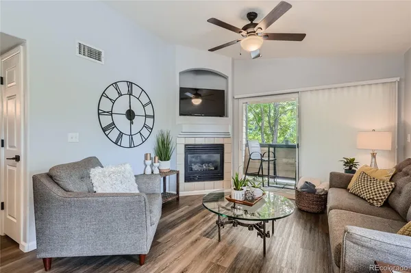 a living room with furniture a fireplace and a large window