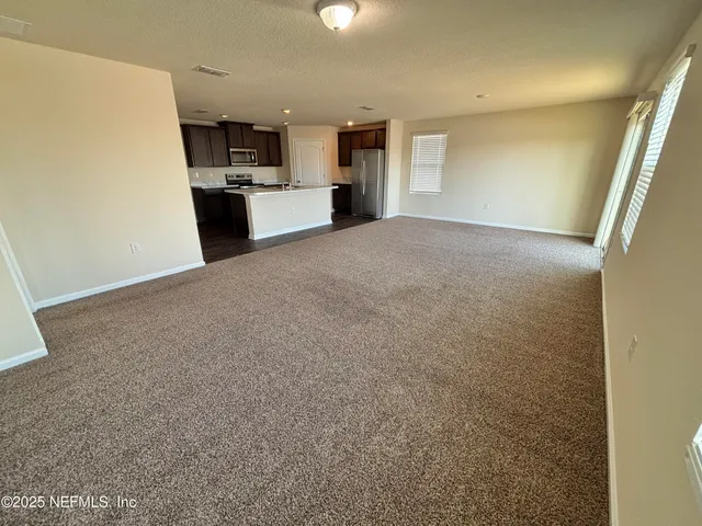 a view of a kitchen with a sink and a refrigerator
